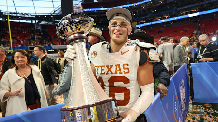 Jan 1, 2025; Atlanta, GA, USA; Texas Longhorns defensive back Michael Taaffe (16) poses with the trophy after a victory over the Arizona State Sun Devils in the Peach Bowl at Mercedes-Benz Stadium. Mandatory Credit: Brett Davis-Imagn Images