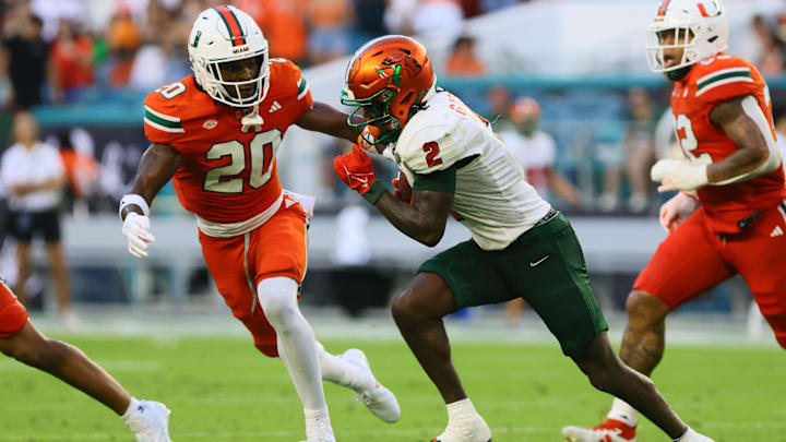 Sep 7, 2024; Miami Gardens, Florida, USA; Florida A&M Rattlers wide receiver Jamari Gassett (2) runs with the football against Miami Hurricanes defensive back Zaquan Patterson (20) during the second quarter at Hard Rock Stadium. Mandatory Credit: Sam Navarro-Imagn Images
