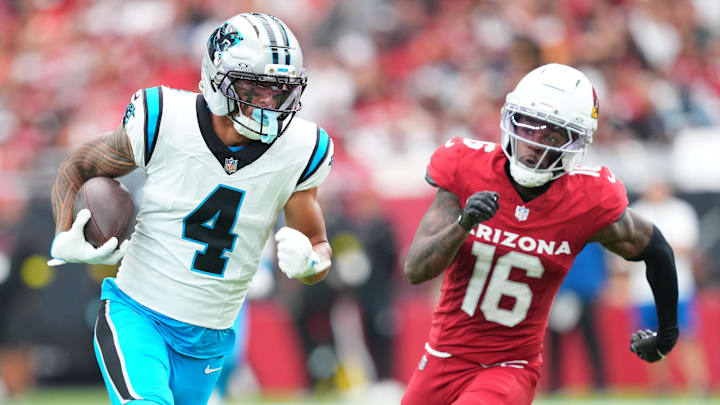 Sep 14, 2025; Glendale, Arizona, USA;  Carolina Panthers wide receiver Tetairoa McMillan (4) runs with the ball during the first quarter against Arizona Cardinals cornerback Max Melton (16) at State Farm Stadium. Mandatory Credit: Joe Camporeale-Imagn Images