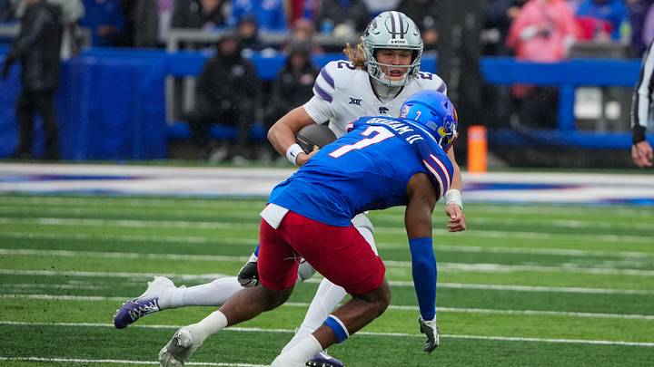 Oct 25, 2025; Lawrence, Kansas, USA; Kansas State Wildcats quarterback Avery Johnson (2) runs the ball as Kansas Jayhawks defensive back DJ Graham II (7) defends during the second half of the game at David Booth Kansas Memorial Stadium. Mandatory Credit: Denny Medley-Imagn Images Oct 25, 2025; Lawrence, Kansas, USA; Kansas State Wildcats quarterback Avery Johnson (2) runs the ball as Kansas Jayhawks defensive back DJ Graham II (7) defends during the second half of the game at David Booth Kansas Memorial Stadium. Mandatory Credit: Denny Medley-Imagn Images