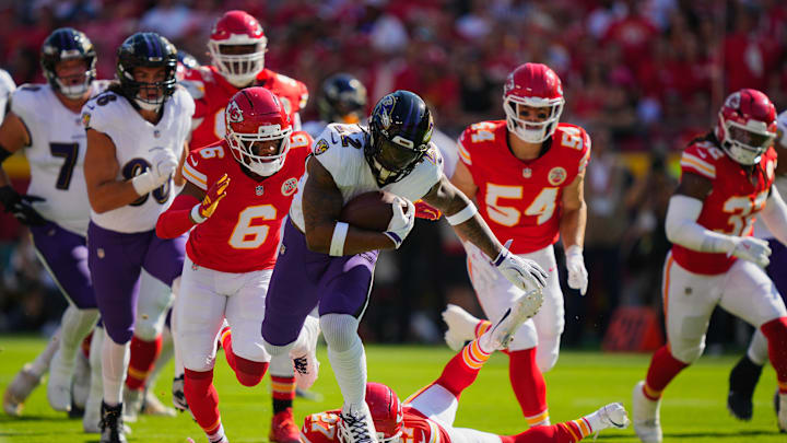Sep 28, 2025; Kansas City, Missouri, USA; Baltimore Ravens running back Derrick Henry (22) rushes as Kansas City Chiefs safety Chamarri Conner (27) and Kansas City Chiefs safety Bryan Cook (6) defend during the first half at GEHA Field at Arrowhead Stadium. Mandatory Credit: Jay Biggerstaff-Imagn Images