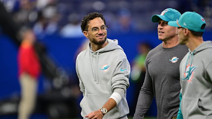Miami Dolphins coach Mike McDaniel talks with his coaching staff while entering the field.