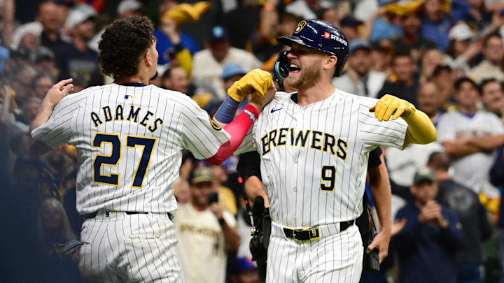 Oct 3, 2024; Milwaukee, Wisconsin, USA; Milwaukee Brewers pinch hitter Jake Bauers (9) celebrates with shortstop Willy Adames (27) after scoring a solo home run against the New York Mets in the seventh inning during game three of the Wildcard round for the 2024 MLB Playoffs at American Family Field. Mandatory Credit: Benny Sieu-Imagn Images