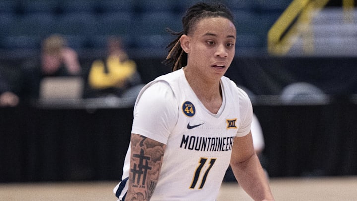 Dec 1, 2024; Estero, FL, USA; West Virginia University JJ Quinerly (11) dribbles the ball during the first quarter of the Women's Gulf Coast Showcase at Hertz Arena. Mandatory Credit: Chris Tilley-Imagn Images