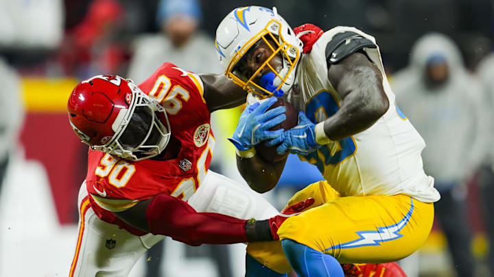 Dec 8, 2024; Kansas City, Missouri, USA; Los Angeles Chargers running back Kimani Vidal (30) is tackled by Kansas City Chiefs defensive end Charles Omenihu (90) during the second half at GEHA Field at Arrowhead Stadium. Mandatory Credit: Jay Biggerstaff-Imagn Images