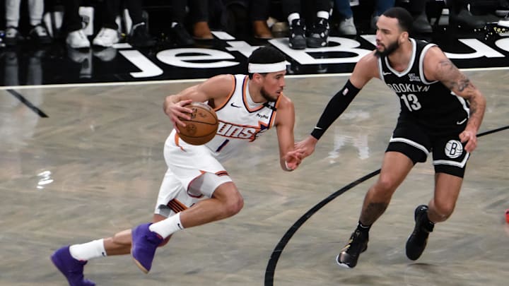 Jan 22, 2025; Brooklyn, New York, USA; Phoenix Suns guard Devin Booker (1) drives to the basket while being defended by Brooklyn Nets guard Tyrese Martin (13) during the second half at Barclays Center. Mandatory Credit: John Jones-Imagn Images