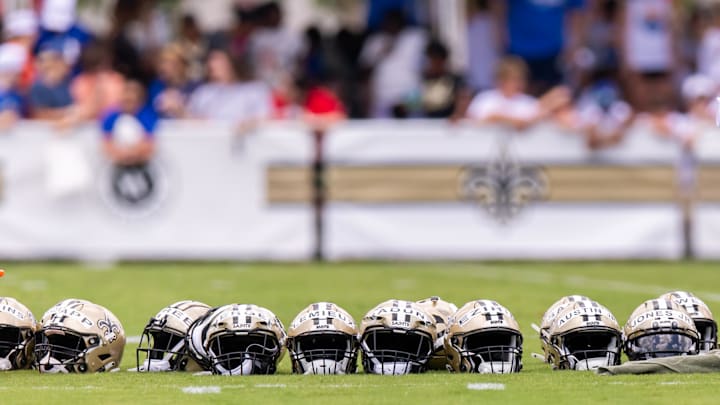 Jun 10, 2025; New Orleans, LA, USA; Detailed view of Saints helmets lined up with fans in the background during minicamp at Ochsner Sports Performance Center. Mandatory Credit: Stephen Lew-Imagn Images