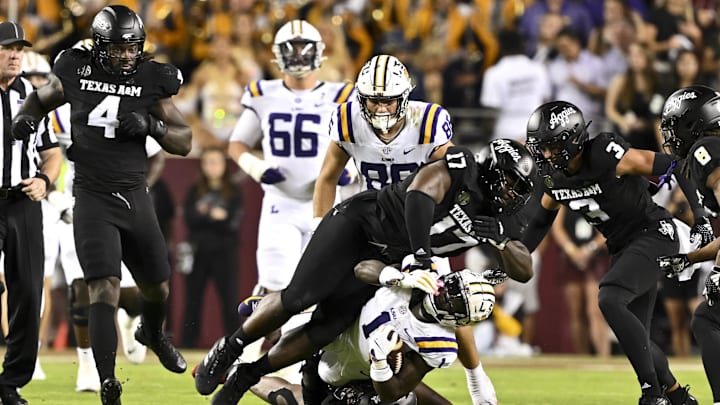 Texas A&M Aggies defensive back Marcus Ratcliffe (3) and defensive lineman Albert Regis (17) tackle LSU Tigers wide receiver Aaron Anderson (1) during the third quarter. The Aggies defeated the Tigers 38-23; at Kyle Field.