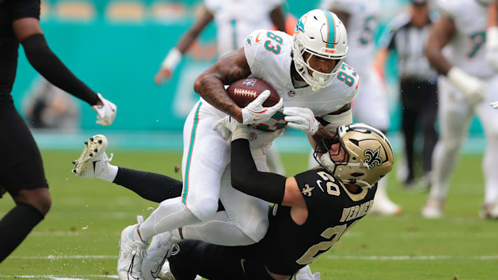 Miami Dolphins tight end Darren Waller (83) is tackled by New Orleans Saints linebacker Pete Werner (20) during the first half at Hard Rock Stadium.