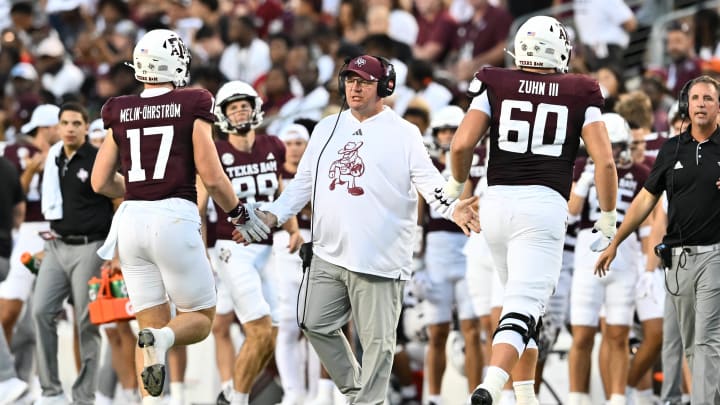 Aug 31, 2024; College Station, Texas, USA; Texas A&M Aggies coach Mike Elko high fives players as they exit the field during the second quarter against the Notre Dame Fighting Irish at Kyle Field. Aug 31, 2024; College Station, Texas, USA; Texas A&M Aggies coach Mike Elko high fives players as they exit the field during the second quarter against the Notre Dame Fighting Irish at Kyle Field.