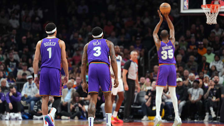 Mar 2, 2025; Phoenix, Arizona, USA; Phoenix Suns guard Devin Booker (1) and Phoenix Suns guard Bradley Beal (3) watch as Phoenix Suns forward Kevin Durant (35) shoots a free throw against the Minnesota Timberwolves during the first half at Footprint Center. Mandatory Credit: Joe Camporeale-Imagn Images