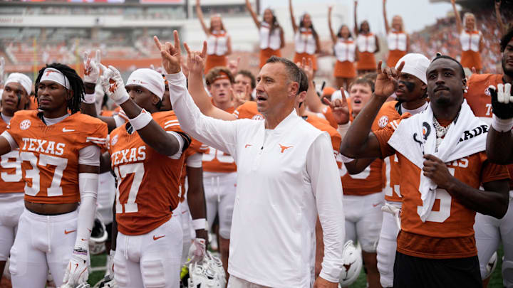 Texas Longhorns head coach Steve Sarkisian and players hold up their horns with the fans during the singing of the Eyes of Texas after a victory over the San Jose State Spartans at Darrell K Royal-Texas Memorial Stadium.