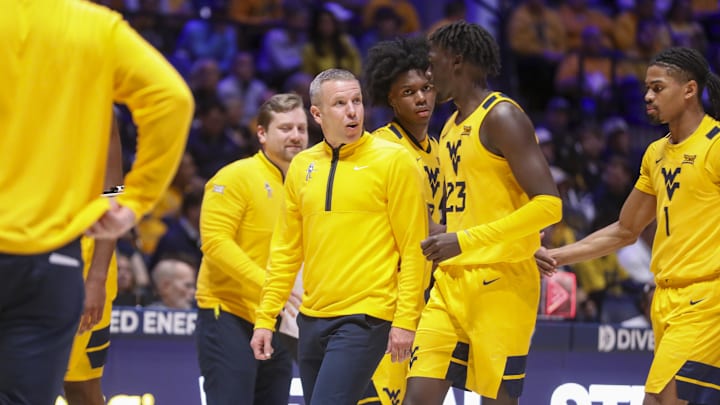 Nov 13, 2025; Morgantown, West Virginia, USA; West Virginia Mountaineers head coach Ross Hodge talks with West Virginia Mountaineers guard Morris Ugusuk (23) during the first half against the Pittsburgh Panthers at WVU Coliseum. Mandatory Credit: Ben Queen-Imagn Images