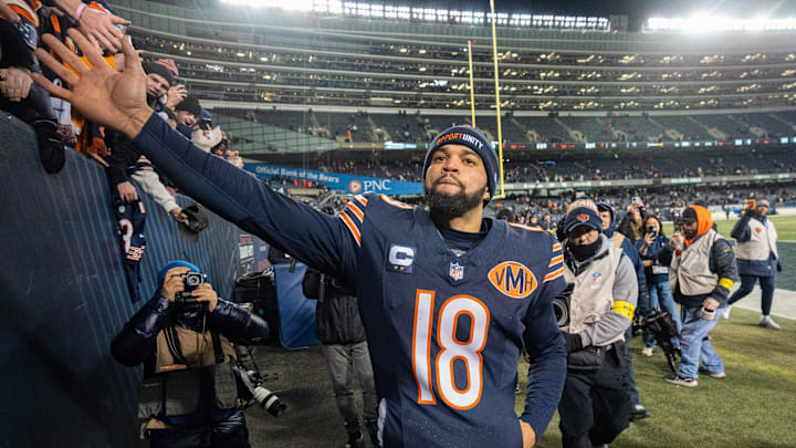 Caleb Williams celebrates with fans after a win that, combined with the Steelers' win over Detroit, put the Bears into the playoffs.