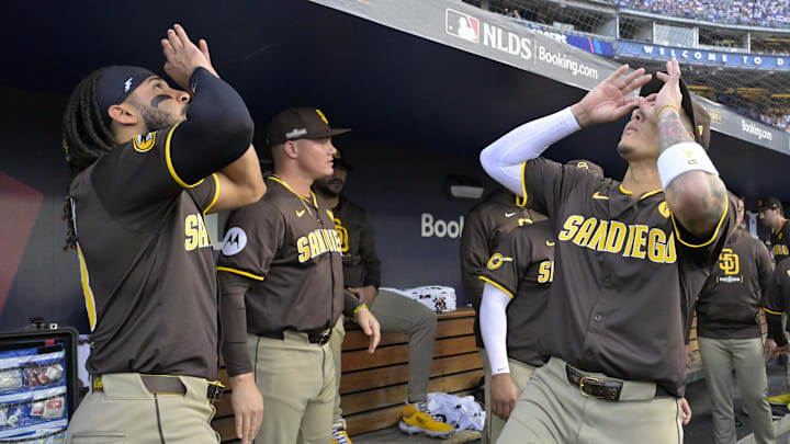 Oct 11, 2024; Los Angeles, California, USA; San Diego Padres outfielder Fernando Tatis Jr. (23) and San Diego Padres third baseman Manny Machado (13) react in the dugout before game five against the Los Angeles Dodgers in the NLDS for the 2024 MLB Playoffs at Dodger Stadium. Mandatory Credit: Jayne Kamin-Oncea-Imagn Images