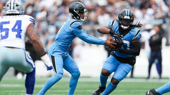 Oct 12, 2025; Charlotte, North Carolina, USA; Carolina Panthers quarterback Bryce Young (9) hands the ball to running back DeeJay Dallas (20) during the first quarter against the Dallas Cowboys at Bank of America Stadium.