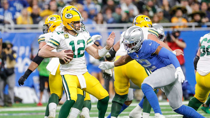 Lions linebacker Jessie Lemonier, center right, looks to tackle Packers quarterback Aaron Rodgers