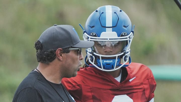 Kentucky offensive coordinator Bush Hamdan talks with quarterback Gavin WImsatt (2) during practice outside Nutter Field House Friday. August 2, 2024 in Lexington.