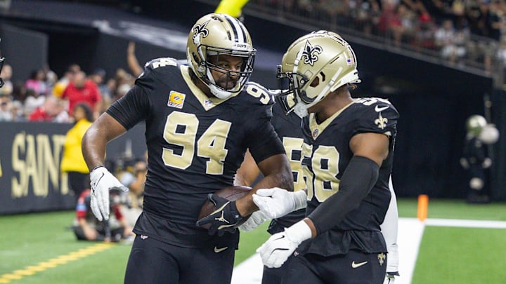Oct 13, 2024; New Orleans, Louisiana, USA;  New Orleans Saints defensive end Cameron Jordan (94) reacts to intercepting the pass of Tampa Bay Buccaneers quarterback Baker Mayfield (6) during the first half at Caesars Superdome. Mandatory Credit: Stephen Lew-Imagn Images