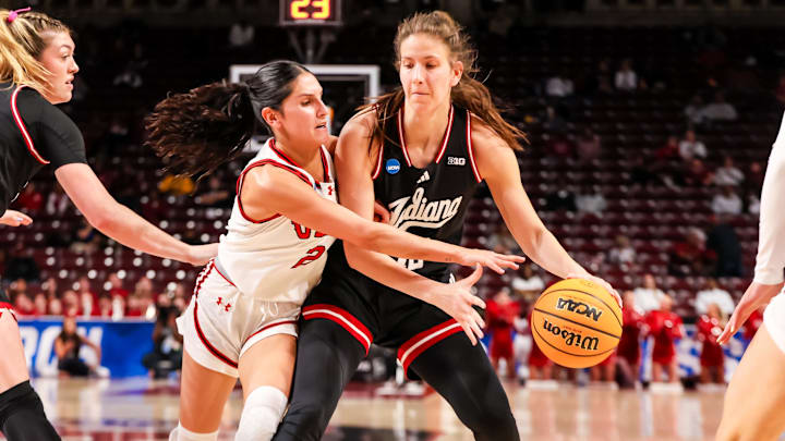 Mar 21, 2025; Columbia, South Carolina, USA; Indiana Hoosiers guard Yarden Garzon (12) attempts to drive around Utah Utes guard Ines Vieira (2) in the first half at Colonial Life Arena. Mandatory Credit: Jeff Blake-Imagn Images