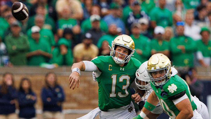Notre Dame quarterback Riley Leonard (13) throws a pass while being tackled during a NCAA college football game between Notre Dame and Louisville at Notre Dame Stadium on Saturday, Sept. 28, 2024, in South Bend.