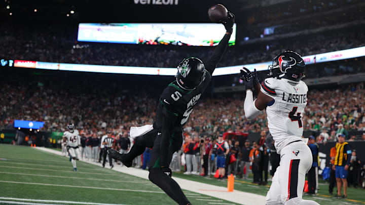Oct 31, 2024; East Rutherford, New Jersey, USA; New York Jets wide receiver Garrett Wilson (5) catches a touchdown pass while being defended by Houston Texans cornerback Kamari Lassiter (4) during the second half at MetLife Stadium. 