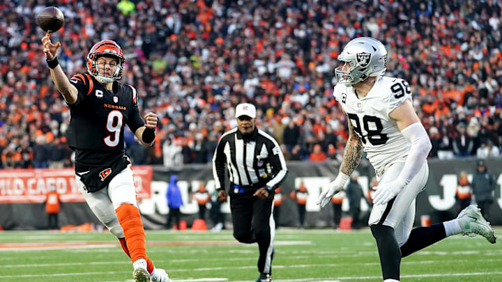 Jan 15, 2022; Cincinnati, OH, USA;  Cincinnati Bengals quarterback Joe Burrow (9) throws as Las Vegas Raiders defensive end Maxx Crosby (98) pressures in the second quarter during an NFL AFC wild-card playoff game, Saturday, Jan. 15, 2022, at Paul Brown Stadium in Cincinnati. Mandatory Credit: Kareem Elgazzar-Imagn Images