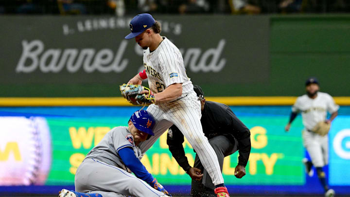 Oct 2, 2024; Milwaukee, Wisconsin, USA; New York Mets second baseman Jose Iglesias (11) slides into second with a double under Milwaukee Brewers shortstop Willy Adames (27) during the second inning in game two of the Wildcard round for the 2024 MLB Playoffs at American Family Field.
