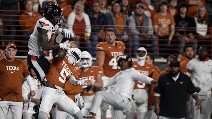 Texas' defensive back Malik Muhammad (5) intercepts a ball intended for Texas Tech's wide receiver Jerand Bradley (9), Friday, Nov. 24, 2023, at Darrell K. Royal-Texas Memorial Stadium in Austin.