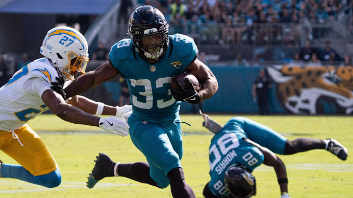 Jacksonville Jaguars running back Bhayshul Tuten (33) eludes a tackle in the second quarter as Los Angeles Chargers safety R.J. Mickens (27) tries to tackle him in an NFL football game at EverBank Stadium, Sunday, November 16, 2025, in Jacksonville, Fla. [Doug Engle/Florida Times-Union]