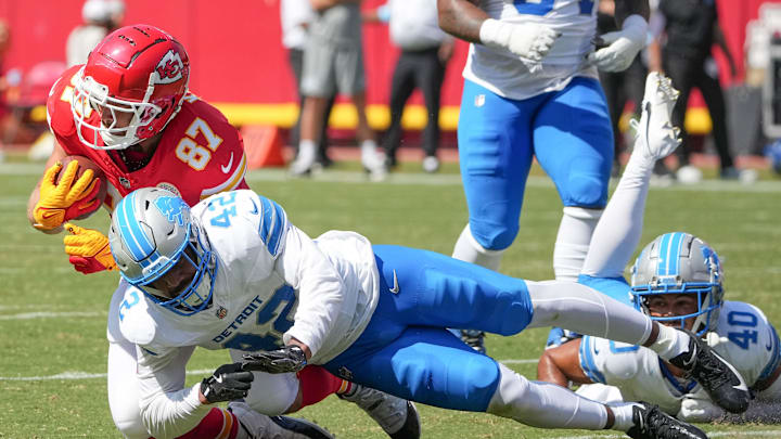Aug 17, 2024; Kansas City, Missouri, USA; Kansas City Chiefs tight end Travis Kelce (87) runs the ball and is tackled by Detroit Lions linebacker Jalen Reeves-Maybin (42) during the game at GEHA Field at Arrowhead Stadium. Mandatory Credit: Denny Medley-Imagn Images
