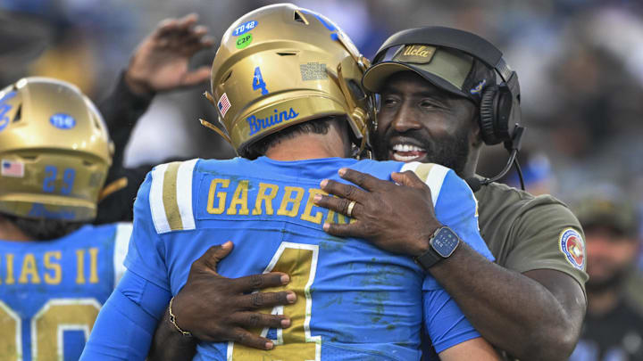 Nov 30, 2024; Pasadena, California, USA; UCLA Bruins head coach DeShaun Foster hugs quarterback Ethan Garbers (4) as time runs out during a Bruins victory over the Fresno State Bulldogs at Rose Bowl. Mandatory Credit: Robert Hanashiro-Imagn Images