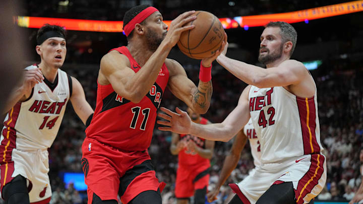Apr 12, 2024; Miami, Florida, USA;  Toronto Raptors forward Bruce Brown (11) goes up for a shot as Miami Heat forward Kevin Love (42) defends during the second half at Kaseya Center. Mandatory Credit: Jim Rassol-Imagn Images