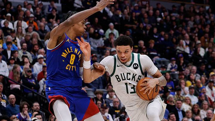 Jan 11, 2026; Denver, Colorado, USA; Milwaukee Bucks guard Ryan Rollins (13) controls the ball against Denver Nuggets guard Peyton Watson (8) as forward Zeke Nnaji (22) defends in the fourth quarter at Ball Arena. Mandatory Credit: Isaiah J. Downing-Imagn Images