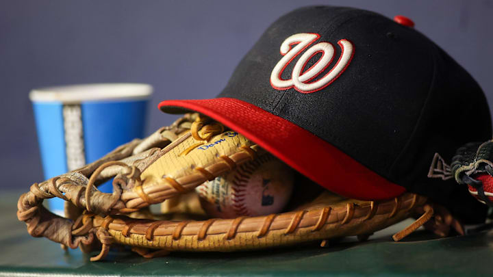 Dark blue Washington Nationals hat on top of a light brown mitt