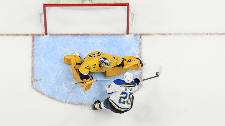 Mar 27, 2025; Nashville, Tennessee, USA;  Nashville Predators goaltender Juuse Saros (74) blocks the shot of St. Louis Blues center Jordan Kyrou (25) during the third period at Bridgestone Arena. Mandatory Credit: Steve Roberts-Imagn Images