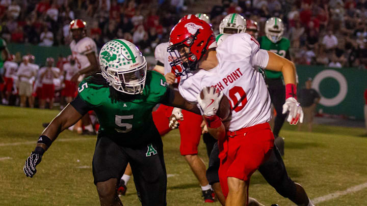 Ashbrook's Caleb Gordon lunges at South Point ball carrier Walker Spargo during their Sept. 19, 2025 matchup in Gastonia. The Green Wave won, 20-14.