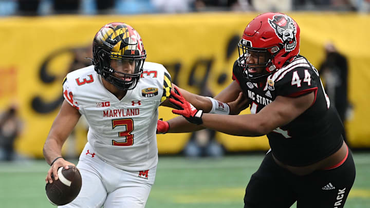 Dec 30, 2022; Charlotte, NC, USA; Maryland Terrapins quarterback Taulia Tagovailoa (3) scrambles as North Carolina State Wolfpack defensive lineman Brandon Cleveland (44) defends in the fourth quarter in the 2022 Duke's Mayo Bowl at Bank of America Stadium. Mandatory Credit: Bob Donnan-Imagn Images