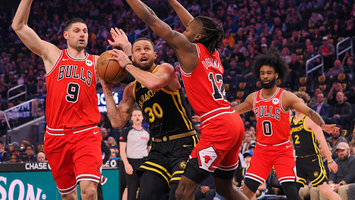 Golden State Warriors guard Stephen Curry (30) drives between Chicago Bulls center Nikola Vucevic (9) and guard Ayo Dosunmu (12) during the first quarter at Chase Center. Mandatory Credit: Kelley L Cox-Imagn Images