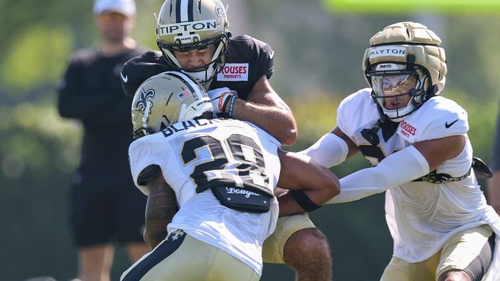 Jul 28, 2025; Metairie, LA, USA;  New Orleans Saints wide receiver Mason Tipton (15) is hit on a pass by safety Julian Blackmon (28) at Ochsner Sports Performance Center. Mandatory Credit: Stephen Lew-Imagn Images