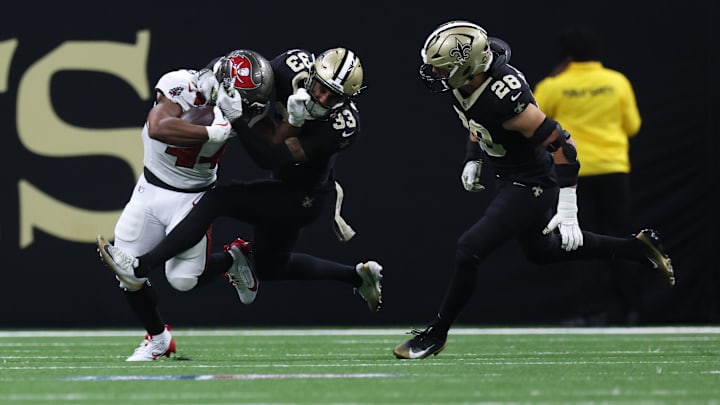Oct 26, 2025; New Orleans, Louisiana, USA; Tampa Bay Buccaneers running back Sean Tucker (44) runs for a gain past New Orleans Saints safety Jonas Sanker (33) and safety Julian Blackmon (28) during the second quarter at Caesars Superdome. Mandatory Credit: Stephen Lew-Imagn Images Oct 26, 2025; New Orleans, Louisiana, USA; Tampa Bay Buccaneers running back Sean Tucker (44) runs for a gain past New Orleans Saints safety Jonas Sanker (33) and safety Julian Blackmon (28) during the second quarter at Caesars Superdome. Mandatory Credit: Stephen Lew-Imagn Images