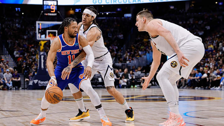 New York Knicks guard Jalen Brunson (11) controls the ball under pressure from Denver Nuggets forward Aaron Gordon (50) as center Nikola Jokic (15) defends in the third quarter at Ball Arena. Mandatory Credit: Isaiah J. Downing-Imagn Images