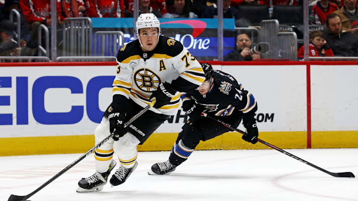 Dec 31, 2024; Washington, District of Columbia, USA; Boston Bruins defenseman Charlie McAvoy (73) skates with the puck against Washington Capitals center Connor McMichael (24) at Capital One Arena. Mandatory Credit: Peter Casey-Imagn Images