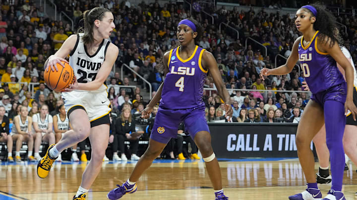 Apr 1, 2024; Albany, NY, USA; Iowa Hawkeyes guard Caitlin Clark (22) controls the ball against LSU Lady Tigers guard Flau'jae Johnson (4) and LSU Lady Tigers forward Angel Reese (10) in the third quarter in the finals of the Albany Regional in the 2024 NCAA Tournament at MVP Arena. Mandatory Credit: Gregory Fisher-Imagn Images