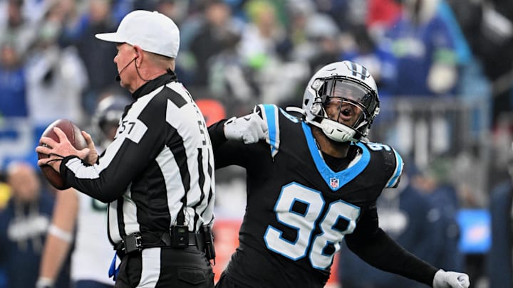 Dec 28, 2025; Charlotte, North Carolina, USA; Carolina Panthers linebacker D.J. Wonnum (98) tosses the ball to referee Carl Cheffers (51) and reacts after sacking Seattle Seahawks quarterback Sam Darnold (not pictured) during the fourth quarter at Bank of America Stadium. Mandatory Credit: Bob Donnan-Imagn Images