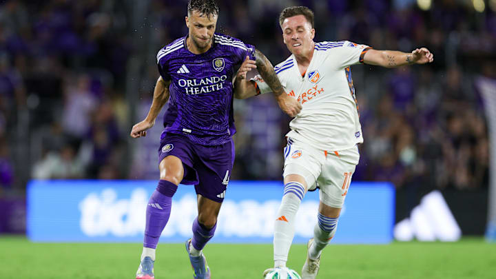 Jun 28, 2025; Orlando, Florida, USA; Orlando City defender David Brekalo (4) and FC Cincinnati forward Corey Baird (11) battle for the ball in the second half at Inter&Co Stadium. Mandatory Credit: Nathan Ray Seebeck-Imagn Images