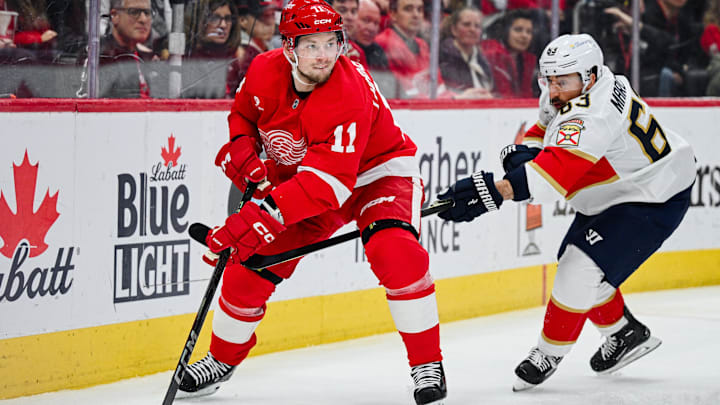 Apr 6, 2025; Detroit, Michigan, USA; Detroit Red Wings right wing Vladimir Tarasenko (11) and Florida Panthers center Brad Marchand (63) battle for the puck during the second period at Little Caesars Arena. Mandatory Credit: Tim Fuller-Imagn Images
