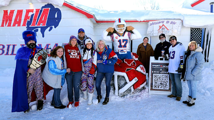 A group of fans pose with a snow sculpture of Josh Allen while tailgating before a 2024 AFC divisional round game between the Buffalo Bills and Kansas City Chiefs at Highmark Stadium.