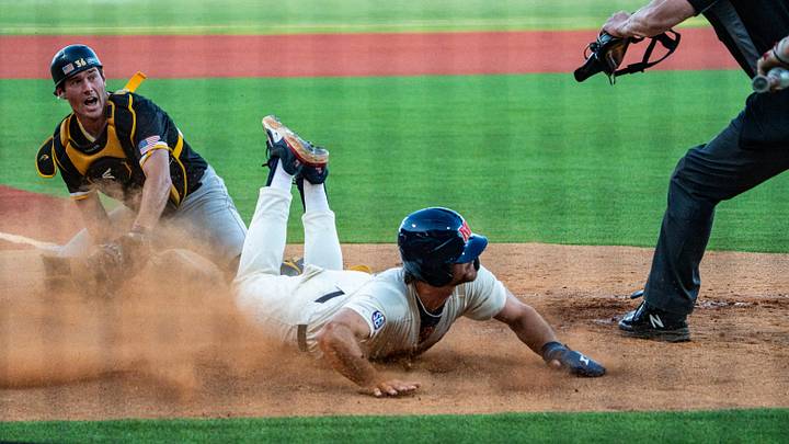 Ole Miss infielder Judd Utermark slides into home plate as Southern Miss catcher Tucker Stockman looks at the umpire for the call during a college baseball game between Ole Miss and Southern Miss Ole Miss infielder Judd Utermark slides into home plate as Southern Miss catcher Tucker Stockman looks at the umpire for the call during a college baseball game between Ole Miss and Southern Miss