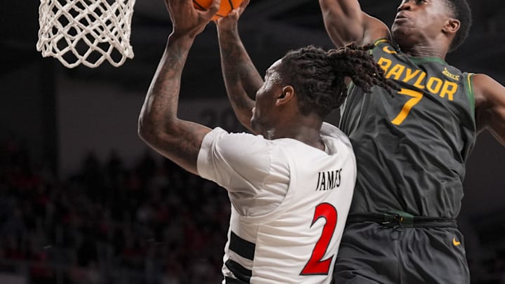 Feb 25, 2025; Cincinnati, Ohio, USA;  Cincinnati Bearcats guard Jizzle James (2) drives to the basket against Baylor Bears guard VJ Edgecombe (7) in the first half at Fifth Third Arena. Mandatory Credit: Aaron Doster-Imagn Images